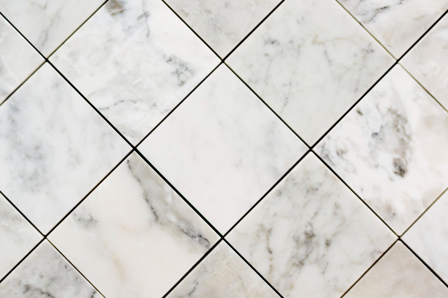 A close up of a white marble tile floor with a checkered pattern.